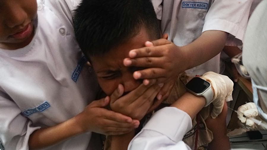 Petugas kesehatan menyuntikkan vaksin Human Papillomavirus (HPV) ke siswa di SDN Palmerah 09, Rabu (5/8/2026). (Bloomberg Technoz/Andrean Kristianto)