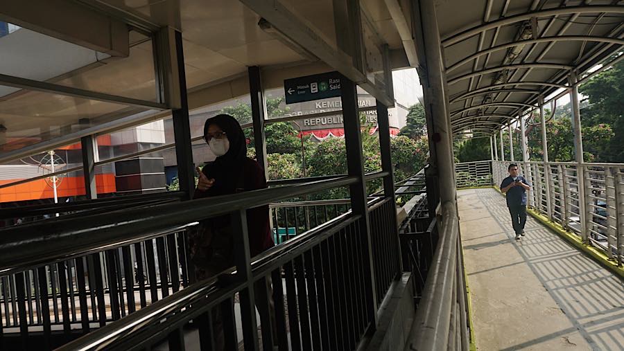 Warga melintas di JPO Rasuna Said, Jakarta, Rabu (5/8/2026). (Bloomberg Technoz/Andrean Kristianto)