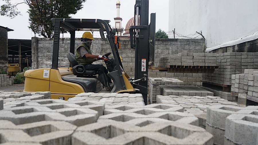 Pekerja memindahkan paving blok di bengkel kerja Rebricks, Jakarta, Jumat (7/8/2026). (Bloomberg Technoz/Andrean Kristianto)