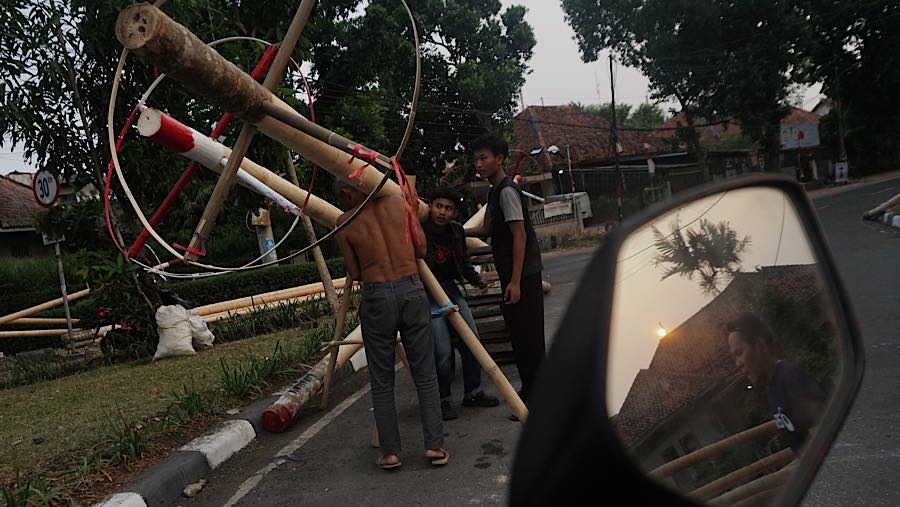 Pekerja memindahkan batang pohon pinang di kawasan Manggarai, Jakarta, Selasa (11/8/2026). (Bloomberg Technoz/Andrean Kristianto)
