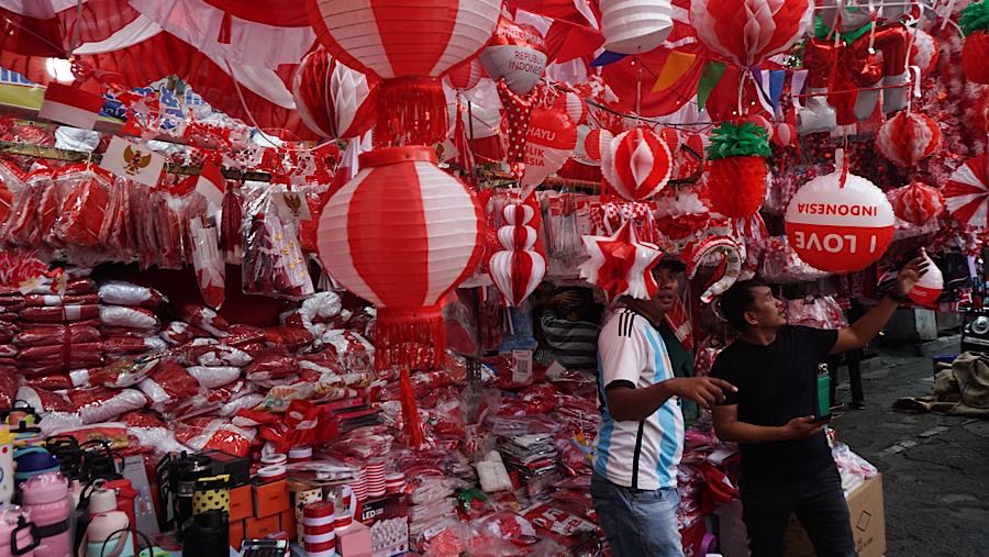 Calon pembeli melihat pernak-pernik kemerdekaan di Pasar Jatinegara, Jakarta, Selasa (11/8/2026). (Bloomberg Technoz/Andrean Kristianto)