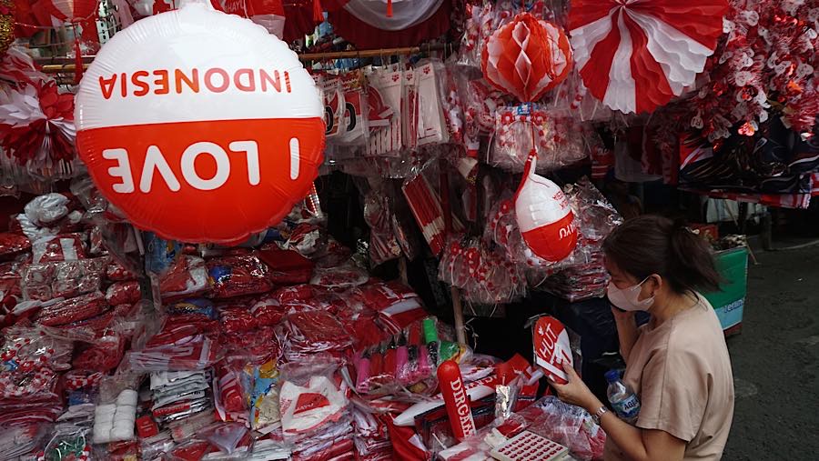 Calon pembeli melihat pernak-pernik kemerdekaan di Pasar Jatinegara, Jakarta, Selasa (11/8/2026). (Bloomberg Technoz/Andrean Kristianto)