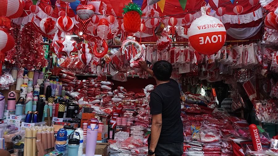 Calon pembeli melihat pernak-pernik kemerdekaan di Pasar Jatinegara, Jakarta, Selasa (11/8/2026). (Bloomberg Technoz/Andrean Kristianto)