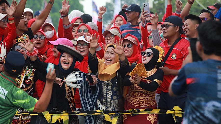 Beberapa pendukung bahkan mengenakan pakaian adat, menambah semarak suasana perlombaan. (Bloomberg Technoz/Andrean Kristianto)