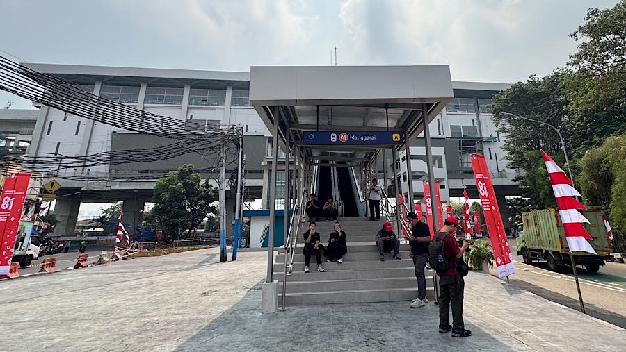 Warga berada di dekat pintu masuk menuju Stasiun LRT Jakarta Manggarai, Kamis (13/8/2026). (Bloomberg Technoz/Andrean Kristianto)