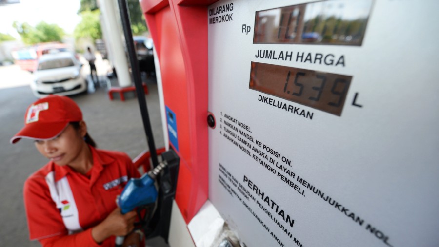 Seorang petugas mengambil nosel pompa bensin di SPBU PT Pertamina di Nusa Dua, Bali, Indonesia./Bloomberg-Dimas Ardian