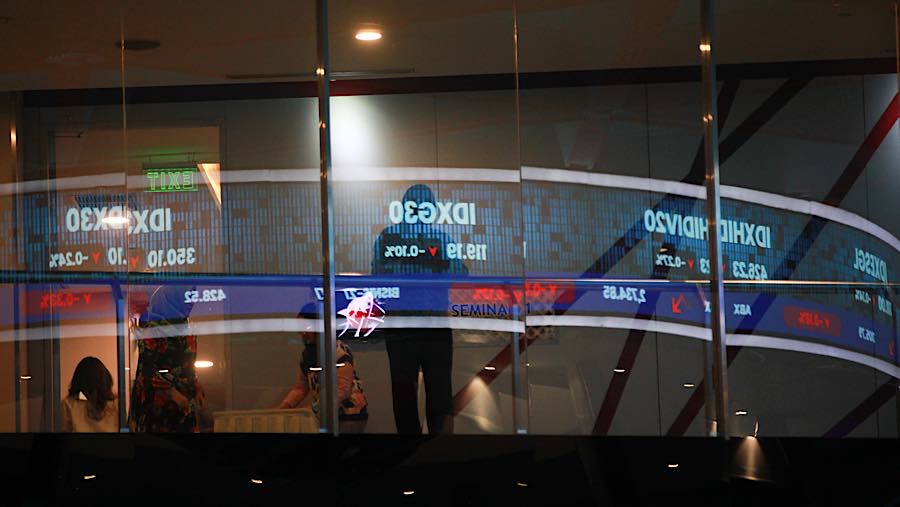 Karyawan di depan layar pergerakan harga saham (IHSG) di Bursa Efek Indonesia (BEI), Jumat (14/8/2026). (Bloomberg Technoz/Andrean Kristianto)
