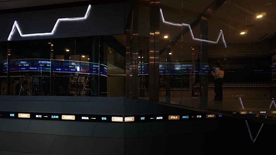 Karyawan di depan layar pergerakan harga saham (IHSG) di Bursa Efek Indonesia (BEI), Jumat (14/8/2026). (Bloomberg Technoz/Andrean Kristianto)