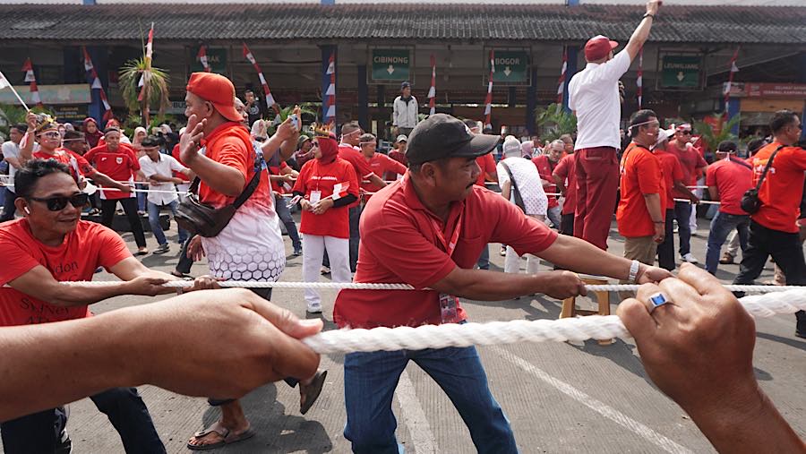 Sebanyak 40 peserta terbagi dalam dua regu mengukuti lomba tarik bus di Terminal Kampung Rambutan. (Bloomberg Technoz/Andrean Kritstianto)