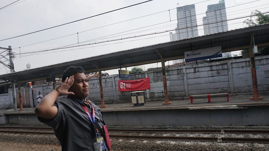 Calon penumpang hormat saat lagu kebangsaan RI diputar di Stasiun Karet, Jakarta, Senin (31/8/2026). (Bloomberg Technoz/Andrean Kristianto)