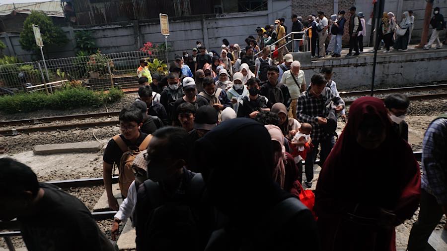 Sejumlah penumpang antre menyeberang rel di Stasiun Karet, Jakarta, Senin (31/8/2026). (Bloomberg Technoz/Andrean Kristianto)