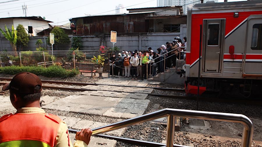 Sejumlah penumpang antre menyeberang rel di Stasiun Karet, Jakarta, Senin (31/8/2026). (Bloomberg Technoz/Andrean Kristianto)