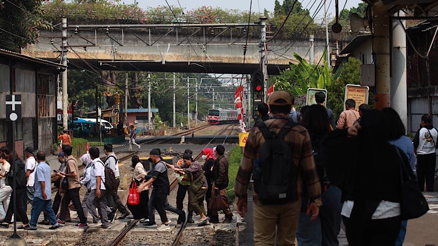 Sejumlah penumpang antre menyeberang rel di Stasiun Karet, Jakarta, Senin (31/8/2026). (Bloomberg Technoz/Andrean Kristianto)