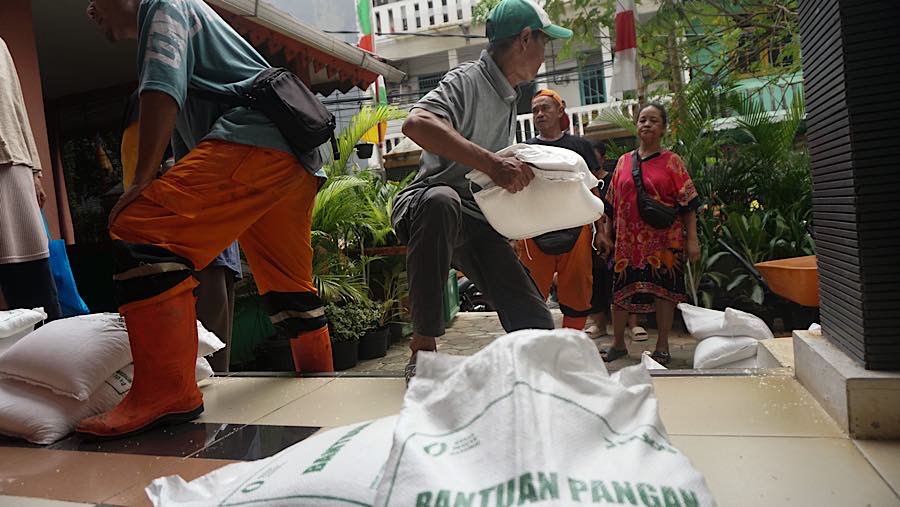 Warga yang telah didata lalu menerima 3 karung beras yang masing-masing beratnya 10kg. (Bloomberg Technoz/Andrean Kristianto)