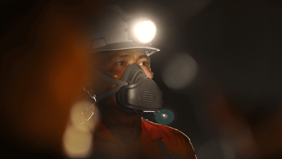 A worker wearing a respiratory mask  inspects the tunnel area underground at Aneka Tambang gold mine in West Java, Indonesia./Bloomberg-Dadang Tri