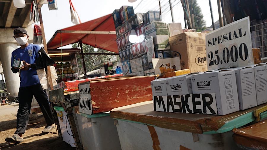 Pedagang merapihkan masker yang dijualnya di Jalan Andara Raya, Pondok Labu, Jakarta, Senin (7/9/2026). (Bloomberg Technoz/Andrean Kristianto)