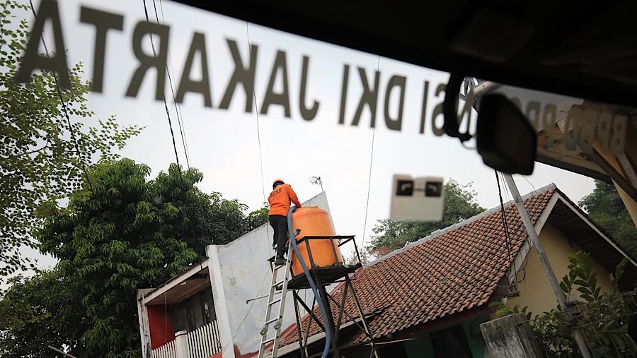 Petugas menyalurkan air bersih ke Jalan Turi dan Jalan Lontar untuk memenuhi kebutuhan warga yang terdampak. (Bloomberg Technoz/Andrean Kristianto)