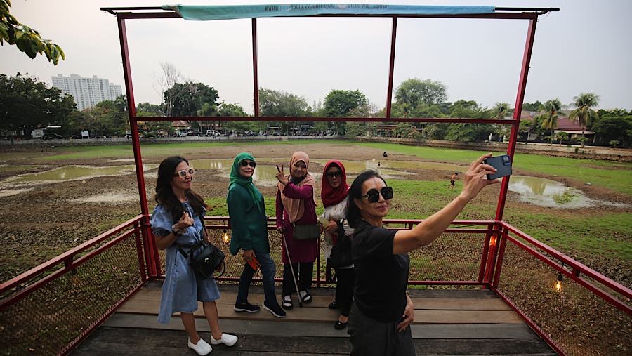Warga berswafoto dengan latar danau Cinere yang surut di Pangkalan Jati, Cinere, Jawa Barat, Senin (21/9/2026) (Bloomberg Technoz/Andrean Kristianto)