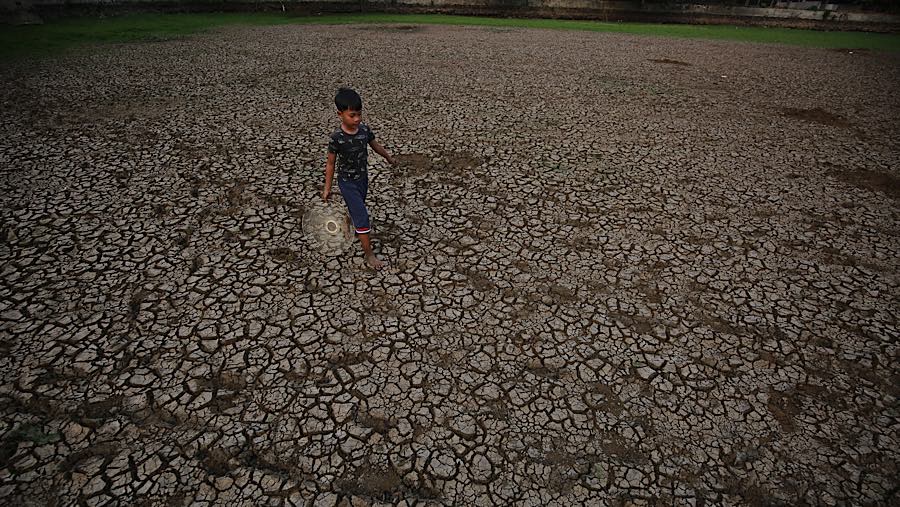 Warga melintasi dasar danau Cinere di Pangkalan Jati, Cinere, Jawa Barat, Senin (21/9/2026) (Bloomberg Technoz/Andrean Kristianto)
