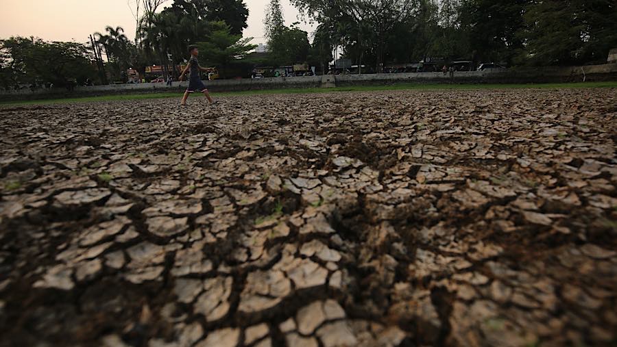Warga melintasi dasar danau Cinere di Pangkalan Jati, Cinere, Jawa Barat, Senin (21/9/2026) (Bloomberg Technoz/Andrean Kristianto)