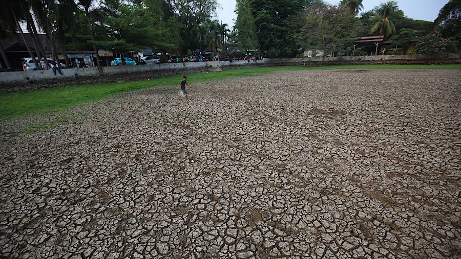 Warga melintasi dasar danau Cinere di Pangkalan Jati, Cinere, Jawa Barat, Senin (21/9/2026) (Bloomberg Technoz/Andrean Kristianto)