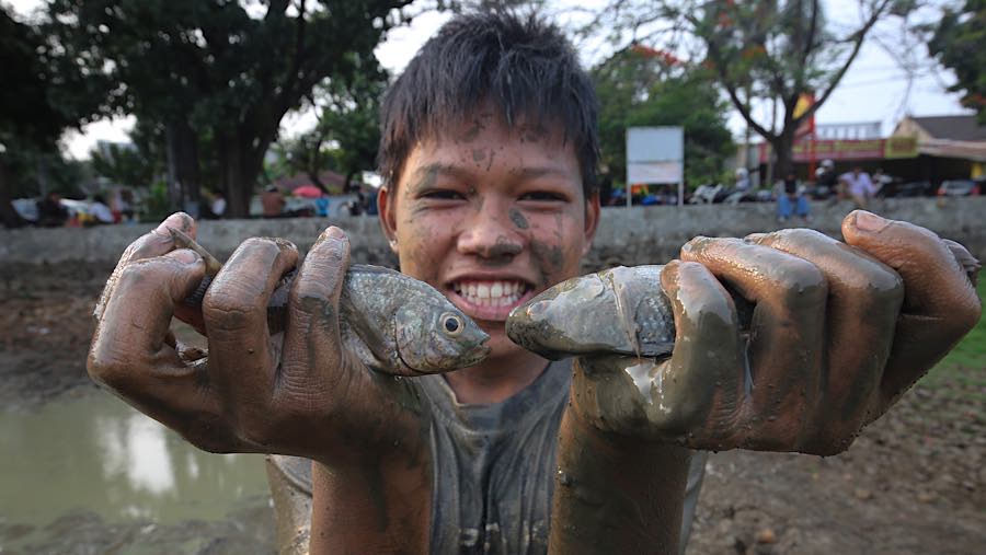 Seorang anak mempelihatkan ikan tangkapannya di Danau Cinere, Pangkalan Jati, Cinere, Jawa Barat, Jumat (25/9/2026) (Bloomberg Technoz/Andrean K)
