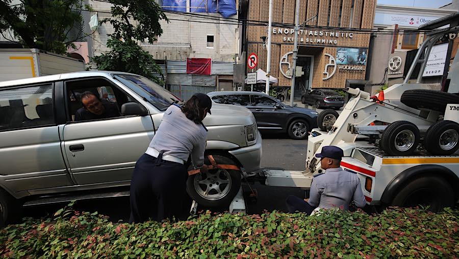 Petugas melakukan penertiban parkir liar di Jalan Senopati, Kebayoran Baru, Jakarta Selatan, Senin (28/9/2026). (Bloomberg Technoz/Andrean Kristianto)