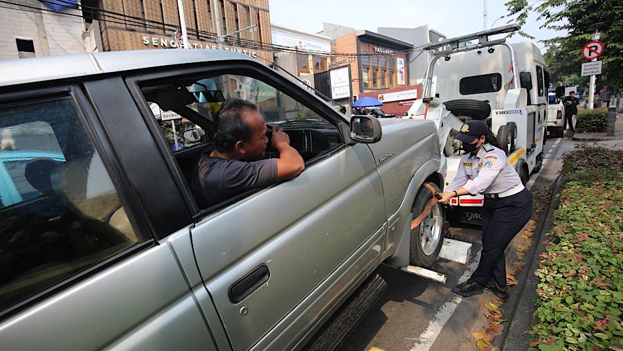 Petugas gabungan melakukan penertiban parkir di trotoar Jalan Senopati, Kebayoran Baru, Jakarta Selatan (Bloomberg Technoz/Andrean Kristianto)