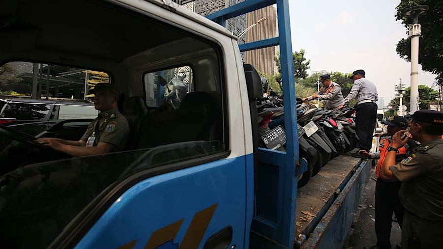 Dari pantauan banyak motor yang terparkir liar diangkut kedalam truk petugas karena menggalangi jalur pedestrian. (Bloomberg Technoz/Andrean K)