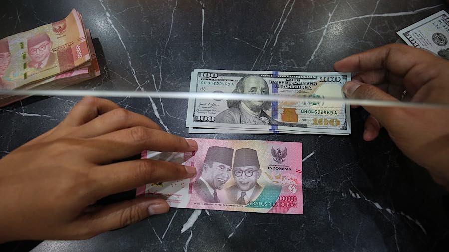 Nasabah menukarkan uang rupiah ke dolar AS di tempat penukaran uang asing di Jakarta, Selasa (29/9/2026). (Bloomberg Technoz/Andrean Kristianto)