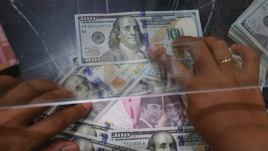 Nasabah menukarkan uang rupiah ke dolar AS di tempat penukaran uang asing di Jakarta, Selasa (29/9/2026). (Bloomberg Technoz/Andrean Kristianto)