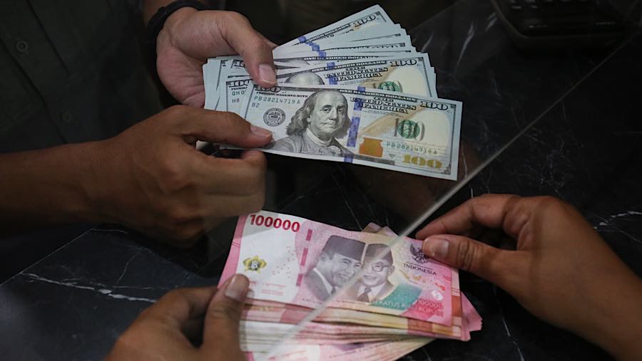 Nasabah menukarkan uang rupiah ke dolar AS di tempat penukaran uang asing di Jakarta, Selasa (29/9/2026). (Bloomberg Technoz/Andrean Kristianto)