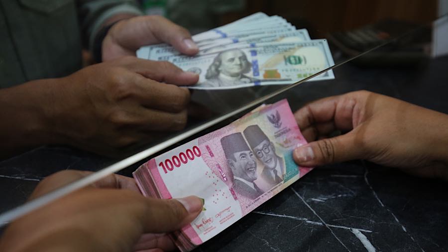 Nasabah menukarkan uang rupiah ke dolar AS di tempat penukaran uang asing di Jakarta, Selasa (29/9/2026). (Bloomberg Technoz/Andrean Kristianto)