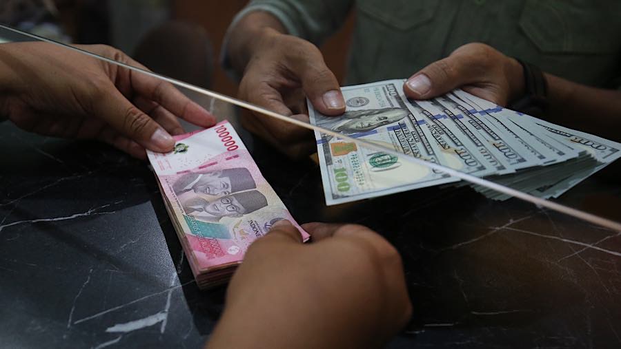 Nasabah menukarkan uang rupiah ke dolar AS di tempat penukaran uang asing di Jakarta, Selasa (29/9/2026). (Bloomberg Technoz/Andrean Kristianto)