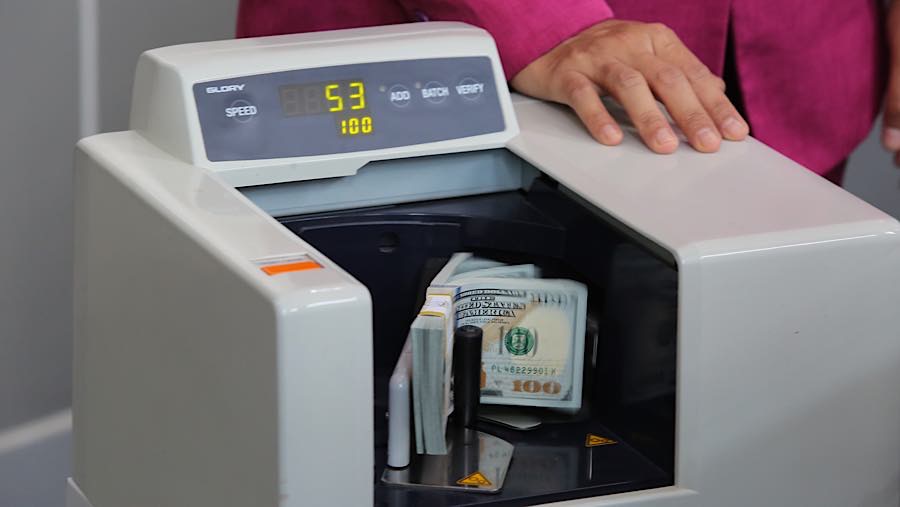 Karyawan menghitung dolar AS di tempat penukaran uang asing di Jakarta, Selasa (29/9/2026). (Bloomberg Technoz/Andrean Kristianto)