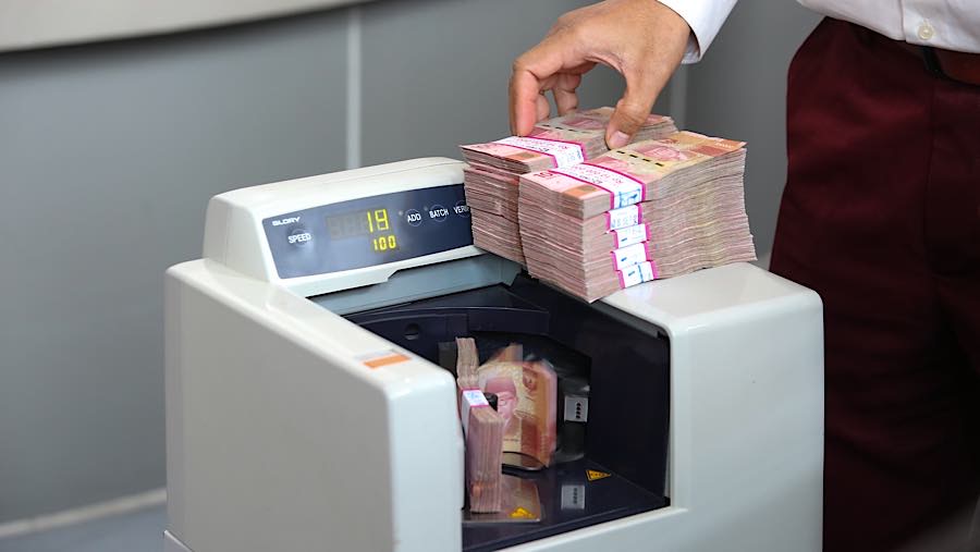 Karyawan menghitung rupiah di tempat penukaran uang asing di Jakarta, Selasa (29/9/2026). (Bloomberg Technoz/Andrean Kristianto)