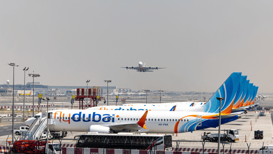 Airbus A380 yang dioperasikan oleh Emirates lepas landas melewati pesawat Flydubai yang sedang parkir di Bandara UEA./Bloomberg-Christopher Pike