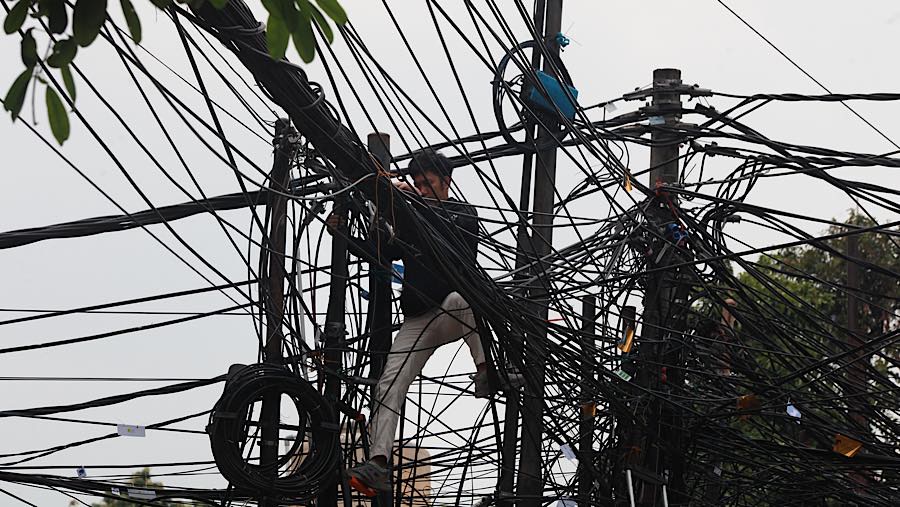 Petugas melakukan penertiban kabel utilitas di Jalan Duren Tiga Raya, Jakarta Selatan, Kamis (8/10/2026). (Bloomberg Technoz/Andrean Kristianto)