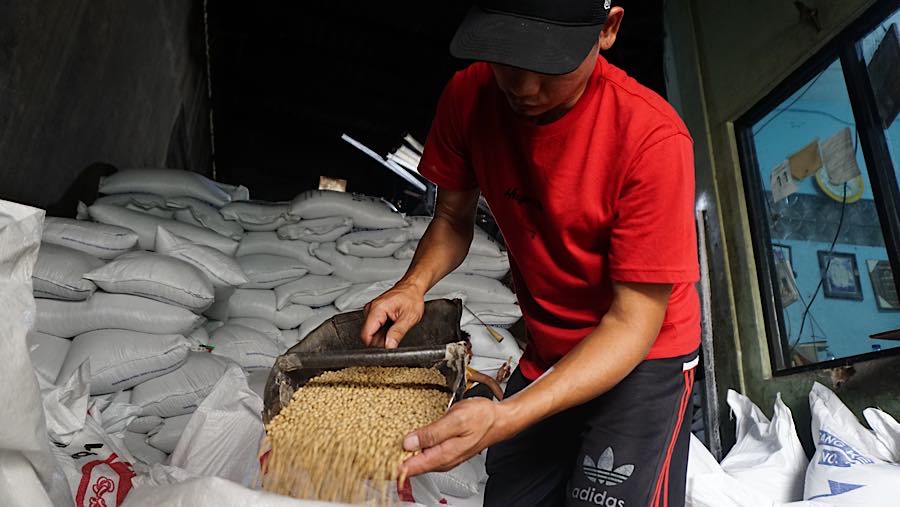 Pekerja menuangkan kedelai ke wadah di Duren Tiga, Jakarta, Kamis (8/10/2026). (Bloomberg Technoz/Andrean Kristianto)