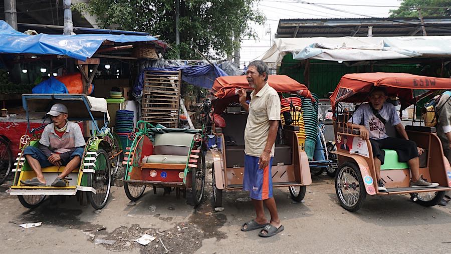 Pengemudi becak listrik menunggu penumpang di kawasan Pasar Kemiri, Depok, Jawa Barat, Senin (12/10/2026). (Bloomberg Technoz/Andrean Kristianto)