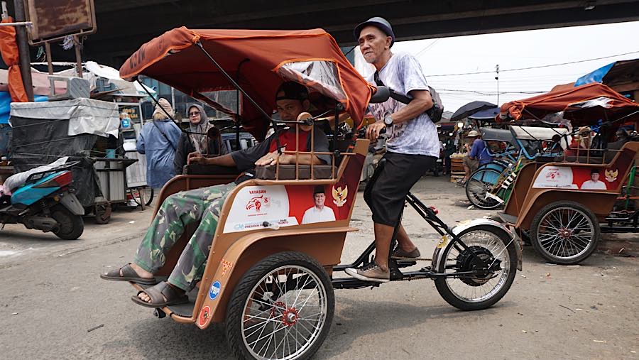 Pengemudi becak listrik mengantarkan penumpang di kawasan Pasar Kemiri, Depok, Jawa Barat, Senin (12/10/2026). (Bloomberg Technoz/Andrean Kristianto)