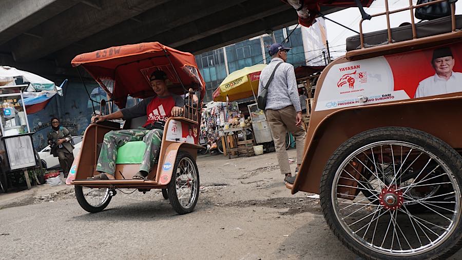 Pengemudi becak listrik mengantarkan penumpang di kawasan Pasar Kemiri, Depok, Jawa Barat, Senin (12/10/2026). (Bloomberg Technoz/Andrean Kristianto)