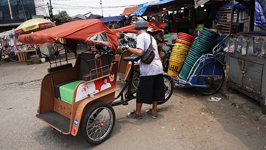 Pengemudi becak listrik menunggu penumpang di kawasan Pasar Kemiri, Depok, Jawa Barat, Senin (12/10/2026). (Bloomberg Technoz/Andrean Kristianto)