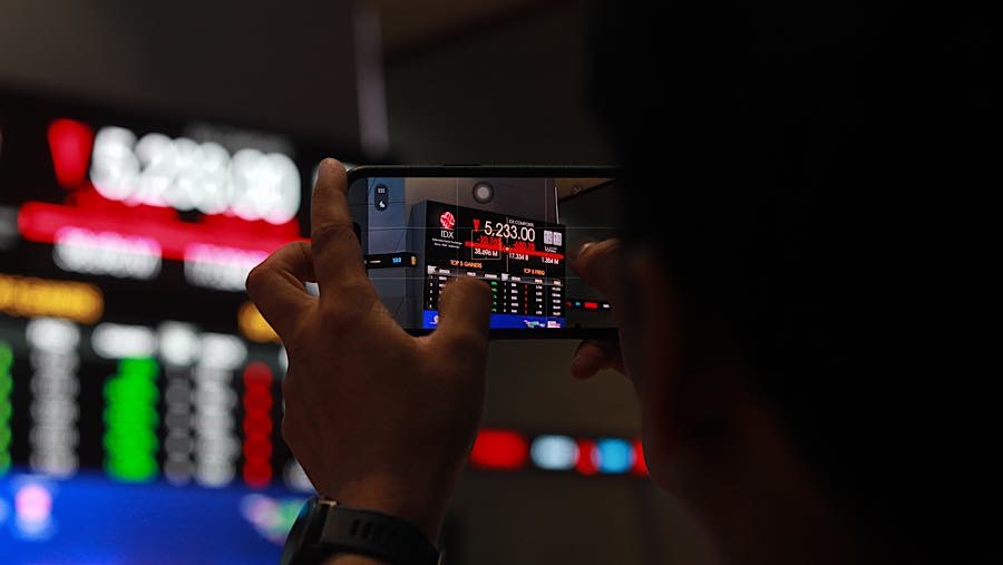 Karyawan di depan layar pergerakan harga saham (IHSG) di Bursa Efek Indonesia (BEI), Jumat (16/10/2026). (Bloomberg Technoz/Andrean Kristianto)