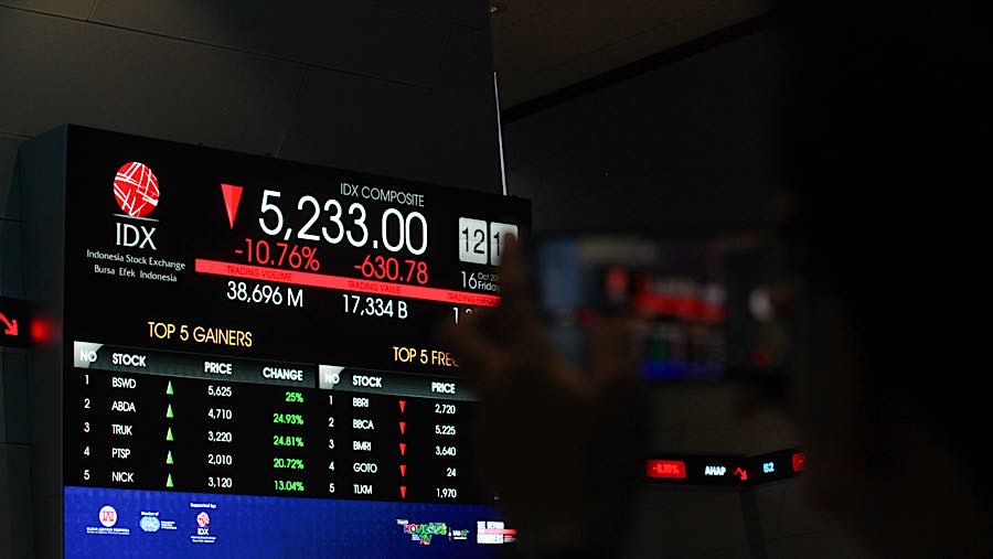 Karyawan di depan layar pergerakan harga saham (IHSG) di Bursa Efek Indonesia (BEI), Jumat (16/10/2026). (Bloomberg Technoz/Andrean Kristianto)