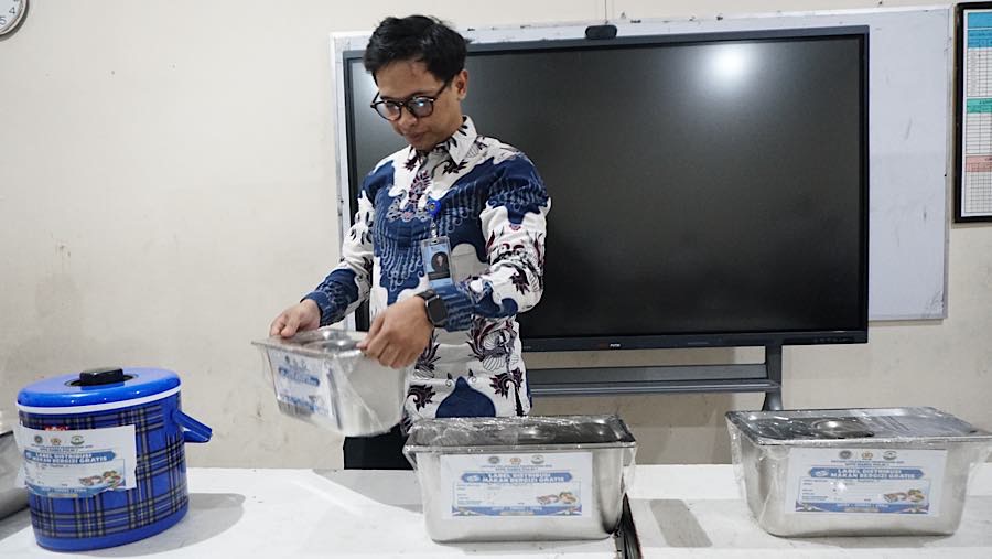 Petugas SPPG menyiapkan MBG secara prasmanan di SMP Kemala Bhayangkari 3, Jakarta, Jumat (16/10/2026). (Bloomberg Technoz/Andrean Kristianto)