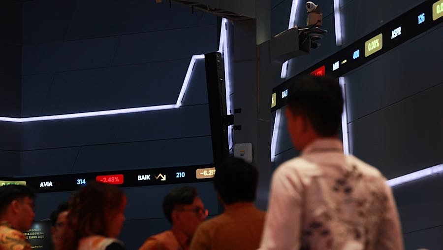 Karyawan di depan layar pergerakan harga saham (IHSG) di Bursa Efek Indonesia (BEI), Senin (19/10/2026). (Bloomberg Technoz/Andrean Kristianto)