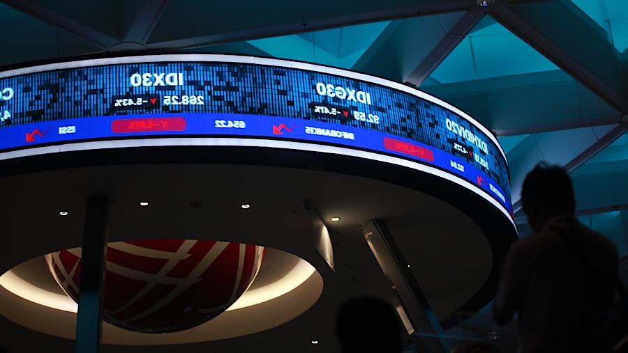 Karyawan di depan layar pergerakan harga saham (IHSG) di Bursa Efek Indonesia (BEI), Senin (19/10/2026). (Bloomberg Technoz/Andrean Kristianto)