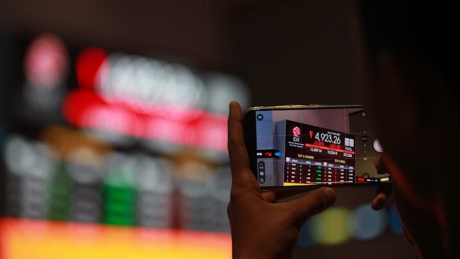 Karyawan di depan layar pergerakan harga saham (IHSG) di Bursa Efek Indonesia (BEI), Senin (19/10/2026). (Bloomberg Technoz/Andrean Kristianto)
