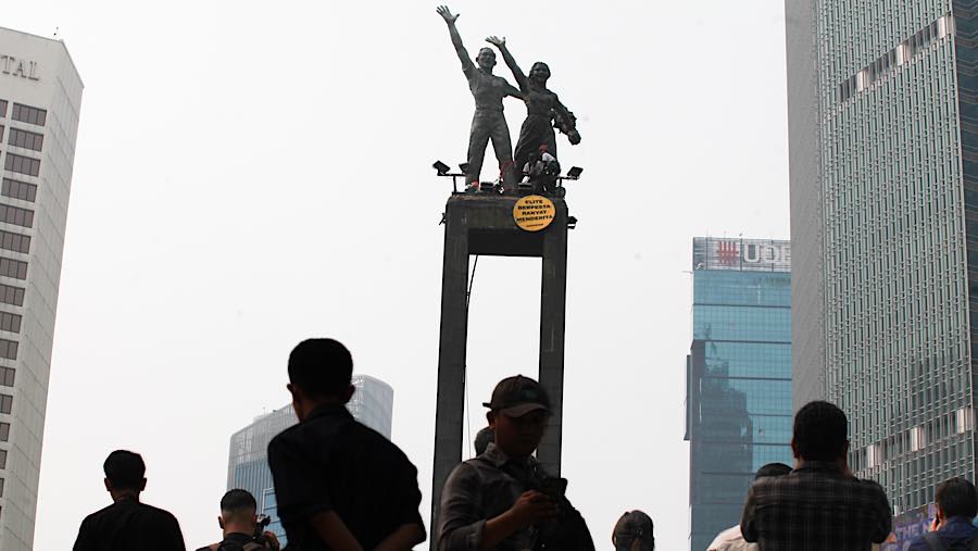Aktivis Greenpeace melakukan aksi di atas Patung Selamat Datang, Bundaran HI, Jakarta, Selasa (20/10/2026). (Bloomberg Technoz/Andrean Kristianto)